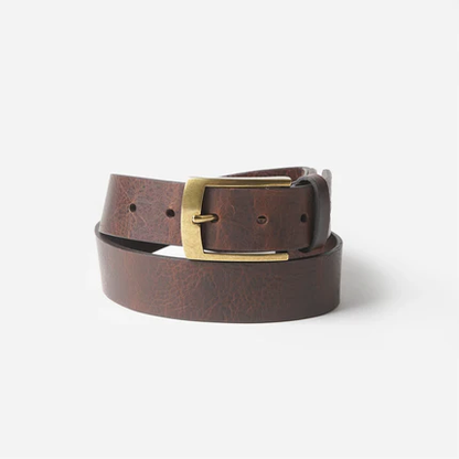 El Cuero full-grain leather belt on white background — brown vegetable-tanned leather with antique brass buckle
