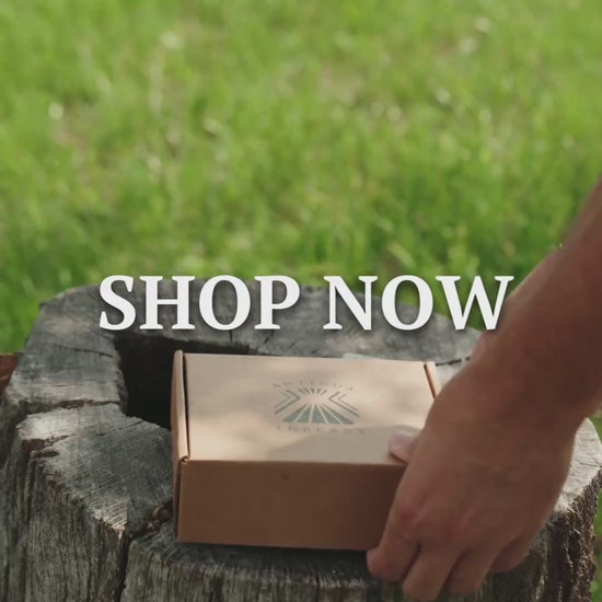 Antigua Threads El Cuero belt unboxing — kraft box with brand logo on a wooden stump